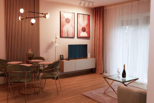 un soggiorno con tavolo da pranzo e televisione di Apartament Milano a Pniewy