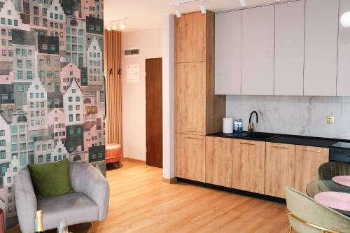 eine Küche mit einem Sofa und einem Stuhl in einem Zimmer in der Unterkunft Apartament Milano in Pniewy