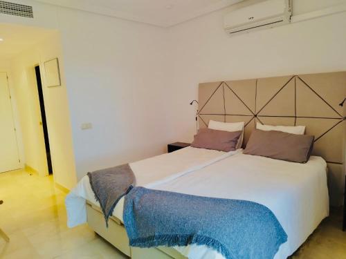 a bedroom with a large white bed with pillows at Los Arqueros Las Jacarandas in Benahavís