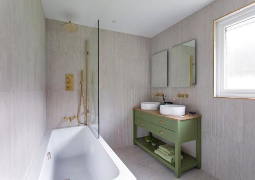 a bathroom with a tub and a sink and a bath tub at Overthickside Cottage in Jedburgh