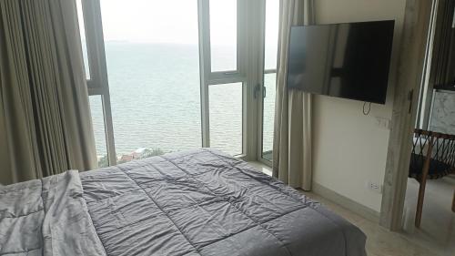 a bedroom with a bed and a large window at The Riviera Monaco in Na Jomtien
