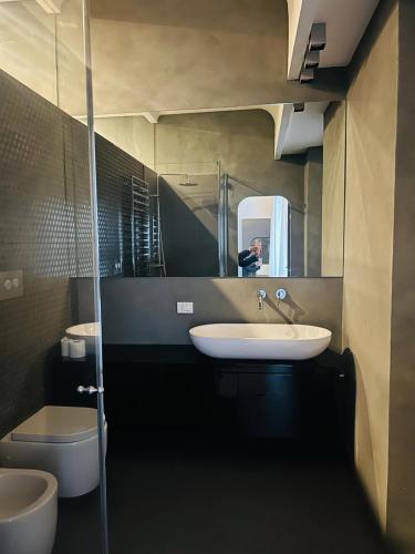 a bathroom with a sink and a toilet and a mirror at Central Hostel Milano in Milan