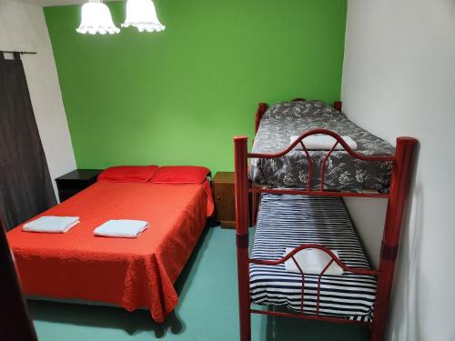 two beds in a room with green walls at LUNA in Comodoro Rivadavia