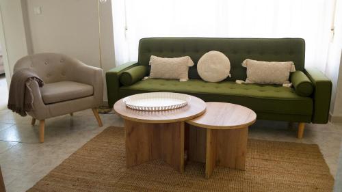 a living room with a green couch and two tables at La Higuera ATCC00793 in Trujillo