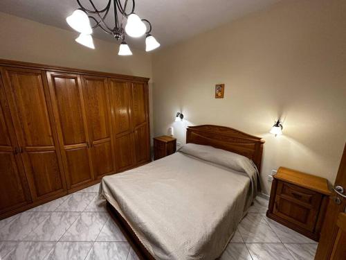 a bedroom with a bed and wooden cabinets at Casa Del Mare, 3Bedroom House in Marsaxlokk Fishing Village in Marsaxlokk