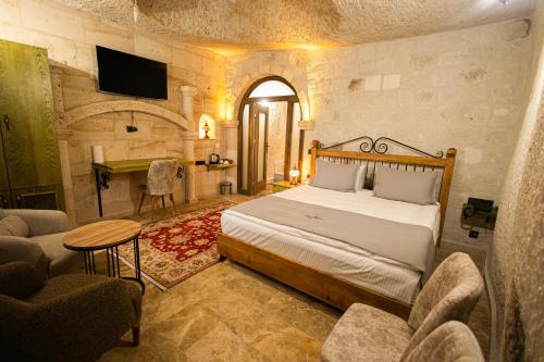 a bedroom with a bed and a living room at Majestic Cave House in Nevsehir