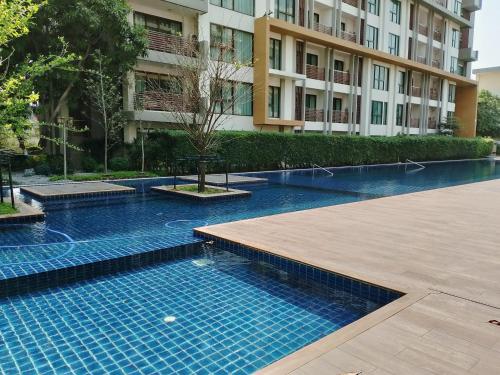 a swimming pool in front of a building at Family&Studio-Room in Phra Nakhon Si Ayutthaya