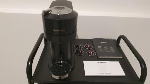 a black blender with a phone and two donuts at Appartamenti Reali Bonaccini in Milan