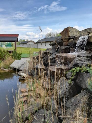 a waterfall in a rock garden with a pond at Apartmány Skleníky Spytihněv in Spytihněv
