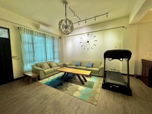 a living room with a couch and a clock on the wall at 澄靛民宿 in Taitung City