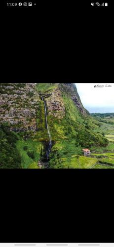 a picture of a mountain with a waterfall on it at Casa vicente in Santa Cruz das Flores