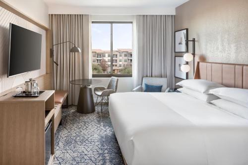a hotel room with a large bed and a television at Sheraton Hotel Stonebriar in The Colony