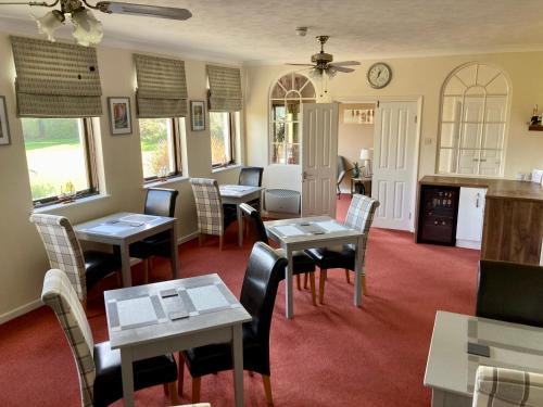 a restaurant with tables and chairs in a room at The Miclaran in Shanklin