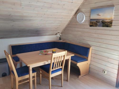 a dining room with a wooden table and chairs at Silbersee90 in Frielendorf