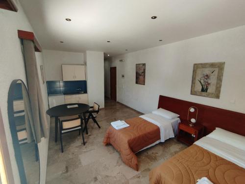 セリアニティカにあるResidenceTheoのベッド2台とテーブルが備わるホテルルームです。