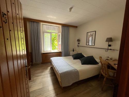 1 dormitorio con cama, escritorio y ventana en Auberge De La Gaichel, en Gaichel