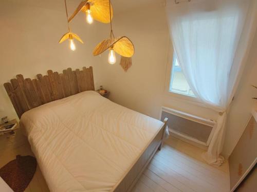 ein kleines Schlafzimmer mit einem Bett und einem Fenster in der Unterkunft Le cocon du pêcheur in Trouville-sur-Mer