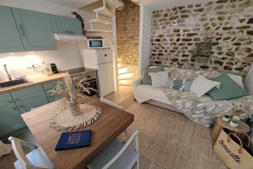 eine Küche und ein Wohnzimmer mit einem Sofa und einem Tisch in der Unterkunft Le cocon du pêcheur in Trouville-sur-Mer