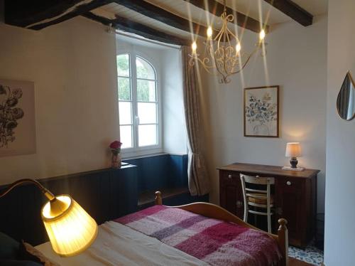 Cette chambre comprend un lit avec une lampe et un bureau. dans l'établissement Maison de charme : Ti Pauline., à Dinan