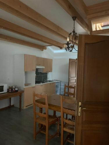 une cuisine avec une table et des chaises dans une pièce dans l'établissement Cedric, à Bassy