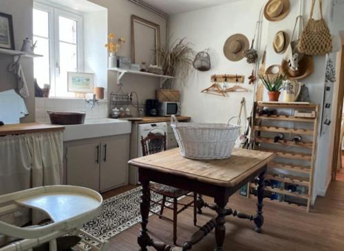 una cocina con una mesa con una cesta. en La Pageotière: une longère normande, en Saint-Denis-sur-Sarthon