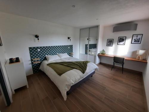 a bedroom with a large bed and a desk at Petit coin de paradis, calme et confort garantie ! in Montauban