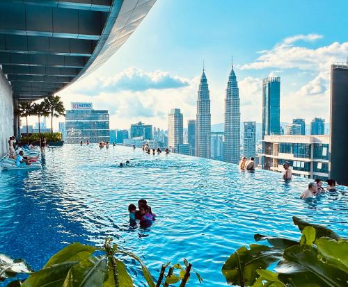 a group of people swimming in a pool in a city at Eaton Service Apartment at KLCC in Kuala Lumpur