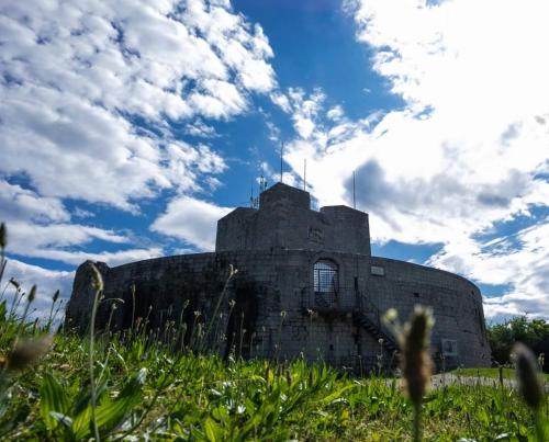 Ein altes Gebäude auf einem Feld mit wolkigem Himmel in der Unterkunft Appartamento Aris in Monfalcone