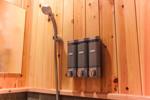 eine Dusche in einer Holzwand mit einem Duschkopf in der Unterkunft Irori no Yado Kinoko - Vacation STAY 76611v in Sakaide