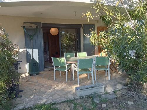 una mesa y sillas en un patio en Le gîte du colombier, en Les Vans