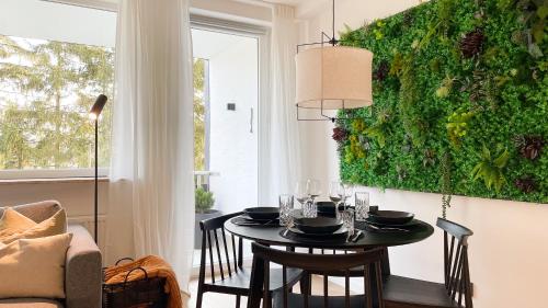 comedor con mesa y pared verde en INSIDE WINTERBERG - Design Apartment - Ski Bike Sauna en Winterberg