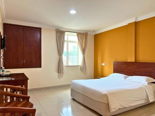 a bedroom with a large bed and a window at Tropicana Hotel in Gemas