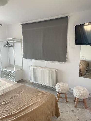 a room with a bed and two stools and a tv at Flat Panorama Sea View Studio for Couples Vrachos in Preveza