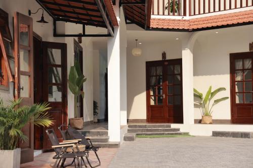 河江的住宿－Anio Ha Giang Hotel，一个带木门和椅子的庭院