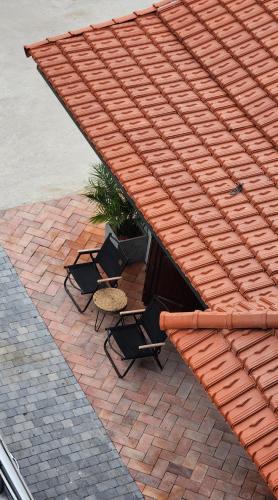 three chairs and a table on a brick patio at Anio Ha Giang Hotel in Ha Giang