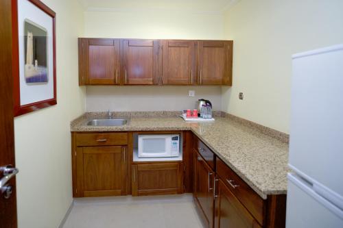 a small kitchen with a sink and a microwave at SAJA Hotels Makkah in Al Masfalah