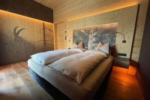 a bedroom with a large bed with white sheets at YAK Hauesl in Fleres