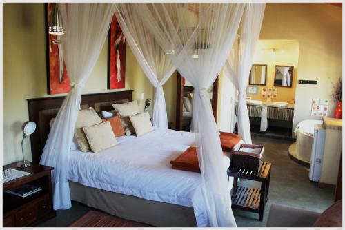 a bedroom with a bed with drapes at Blyde Mountain Country House in Hoedspruit
