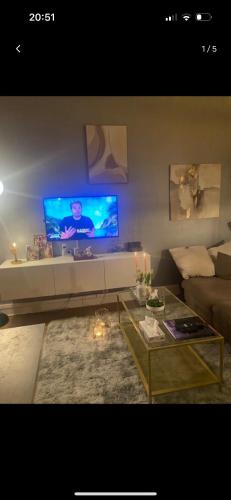 sala de estar con sofá y TV en la pared en Résidence billancourt, en Boulogne-Billancourt