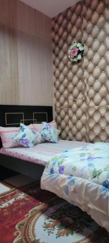 a bedroom with a bed with a padded headboard at MAMA DELIGHT GUEST ROOM in Abu Dhabi