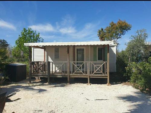 a small house with a large porch in the sand at Camping le clos du thym - Argelès-sur-Mer in Argelès-sur-Mer