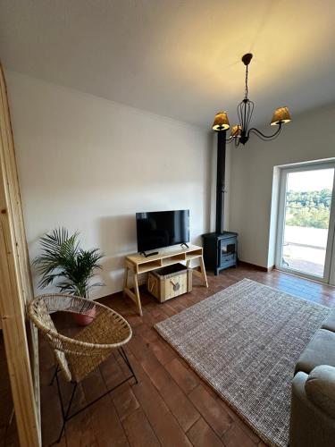a living room with a flat screen tv and a couch at Monte da Caniveta - Casa dos Compadres in São Luis