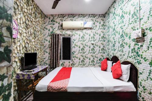 1 dormitorio con 1 cama y escritorio con TV en OYO Flagship Hotel Shreyansh Inn en Cuttack