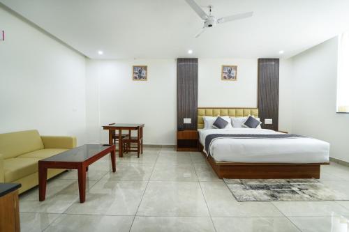 a bedroom with a bed and a couch and a table at RC Comforts in Chikmagalūr