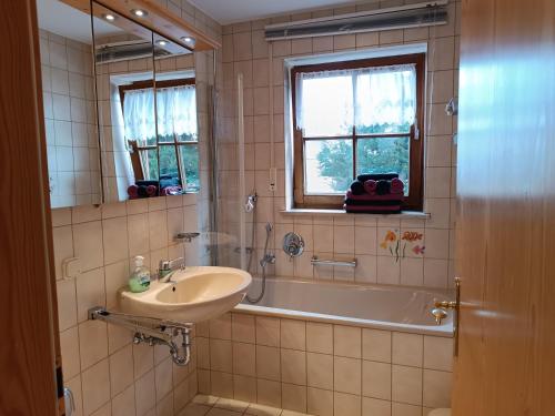 a bathroom with a sink and a bath tub at Hörnerblick in Fischen