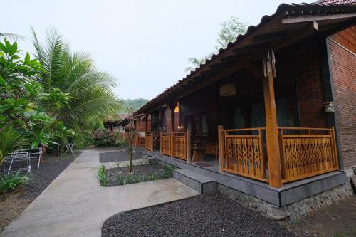 un edificio resort con porche y patio en Java Turtle Lodge Meru Betiri, en Banyuwangi