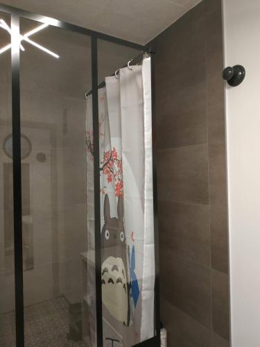 une porte de douche en verre avec rideau de douche et aookyooky dans l'établissement Grand studio idéalement situé, à Chambray-lès-Tours