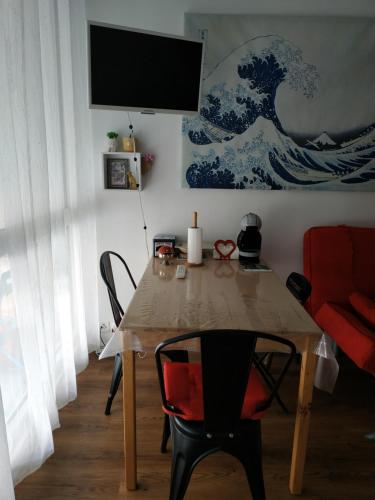 a dining room table with a television on a wall at Grand studio idéalement situé in Chambray-lès-Tours