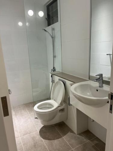 a white bathroom with a toilet and a sink at Homestay KLGCC KL Golf Country Club Senada Residences in Kuala Lumpur