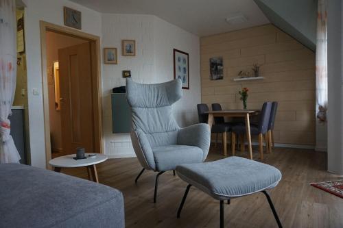 ein Wohnzimmer mit einem Stuhl und einem Tisch in der Unterkunft Vinnenhus Wohnung 06 in Cuxhaven
